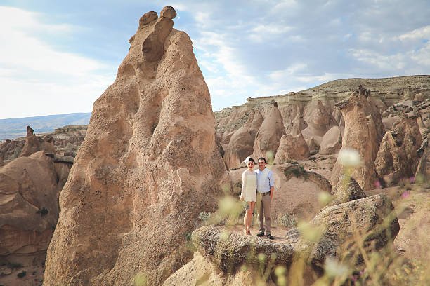 a man and woman standing on a rock